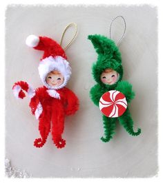 two christmas ornaments are hanging on a white surface