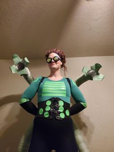 a woman dressed up as a green alien with arms and legs in the shape of an eyeball