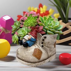 a potted plant sitting on top of a wooden table next to colorful balls and toys