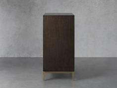 a tall wooden cabinet sitting on top of a cement floor in front of a wall