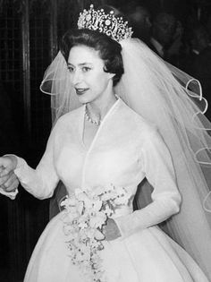 an old black and white photo of a woman in a wedding dress sitting on a couch