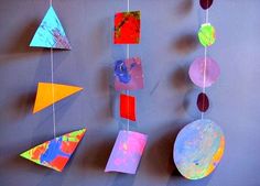 colorful paper shapes hanging from strings on a wall