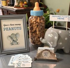 there is a baby bottle with peanuts in it next to an elephant figurine