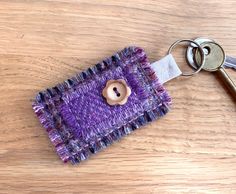 a keychain with a button on it sitting on top of a wooden table