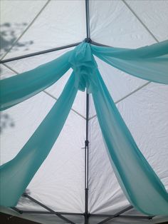 the inside of a white and blue tent with sheer fabric on it's sides