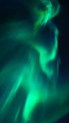 an aurora bore in the night sky with green and blue lights on it's side