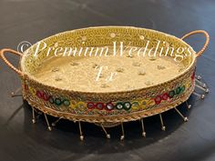 an ornately decorated tray with beaded trimmings sits on a black surface