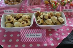 a table topped with bowls filled with desserts next to candy bars and candies