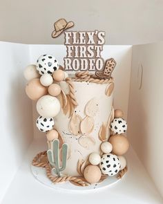 a cake decorated with different types of decorations on top of a white shelf in a room