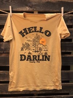 Country Deep Hello Darlin 80's country western unisex Distressed Vintage T shirt available in white and mustard and Green 40 Singles Jersey 100% Cotton Premium quality ringspun and compacted cotton Fine Cotton Jersey that is pigment dyed for a more vintage look Features tears and destroyed features at neck and on body Each piece is unique as this process is done by hand! 3.8 oz Made In USA Every garment dye item can be a slightly different shade in color since this is a laundry dye process. Enjo 80s Country, Hello Darlin, Distressed T Shirt, Country Western, Vintage Look, Vintage Tshirts, Vintage Looks, Mustard, Premium Quality