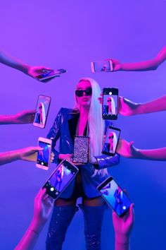 a woman with white hair and sunglasses surrounded by cell phones