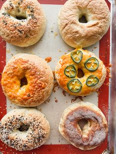 four bagels with different toppings on a tray