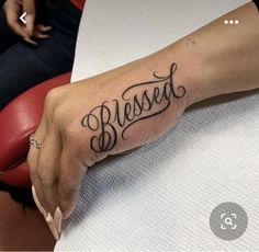 a woman's hand with a tattoo that says, blessed on the left side of her arm