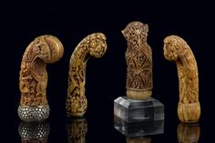 four carved wooden objects sitting next to each other