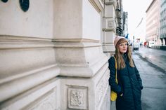 a woman standing on the side of a building