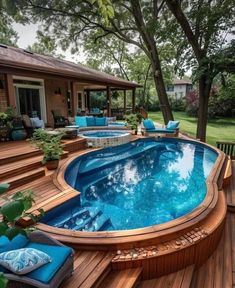 an above ground pool surrounded by wooden decking and blue cushions on the side of it