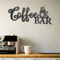 a coffee bar with a sign above it that says coffee bar on the wall next to a cup of coffee