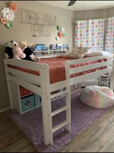 a child's bedroom with a bunk bed and pink rug on the floor next to it