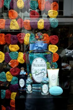 there is a display in the window of a store with yarn and bottles on it