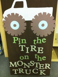 a wooden sign that says pin the tire on the monster truck with two large wheels