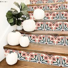 some white pumpkins are sitting on the steps