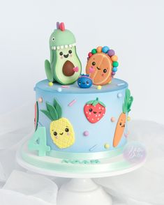 a blue cake decorated with fruit and vegetables