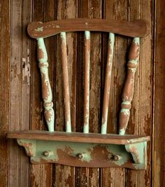 an old wooden chair is hanging on the side of a wall with wood slats