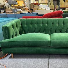 a green couch sitting on top of a carpeted floor