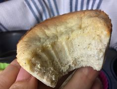 a person holding a piece of bread in their hand