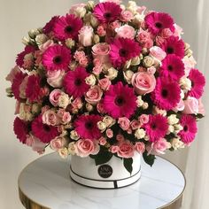 a white vase filled with pink and white flowers