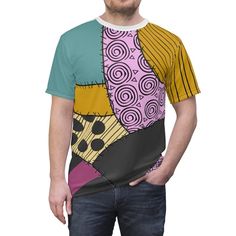 a man standing with his hands in his pockets wearing a t - shirt that has an abstract design on it