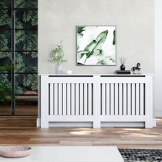 a living room scene with focus on the radiator and wall art above it