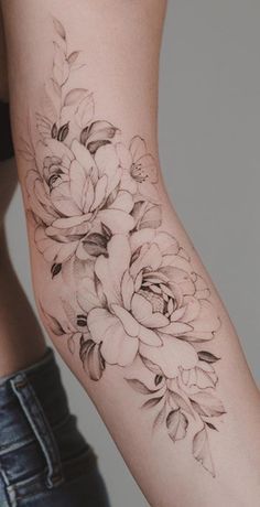 a woman's arm with flowers and leaves tattooed on the left side of her body