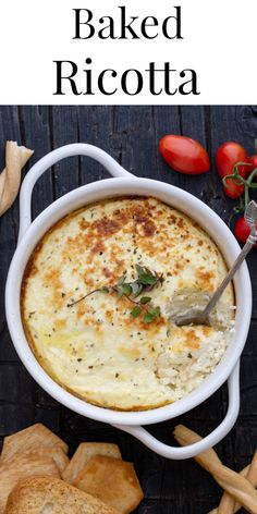 baked ricotta in a white casserole dish surrounded by bread and tomatoes