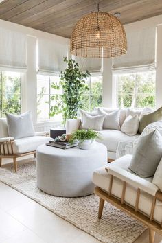 a living room filled with white furniture and lots of windows