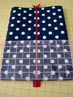 a piece of fabric with white polka dots on it and a red ribbon around the edge