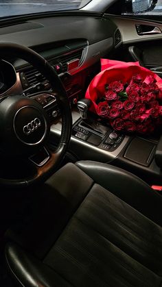 a bouquet of roses sits in the center console of a car