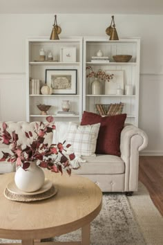 a living room filled with furniture and a coffee table in front of a bookshelf