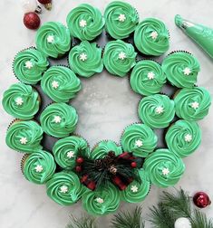 cupcakes are arranged in the shape of a wreath on top of a marble table