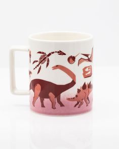 a pink and white mug with dinosaurs on it