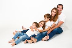 a family sitting on the floor with their arms around each other