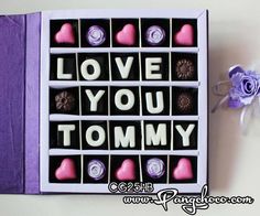 an open box with chocolates in it and the words love you tommy written on them