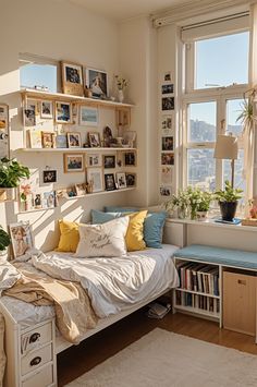 a bed sitting in a bedroom next to a window filled with lots of books and plants