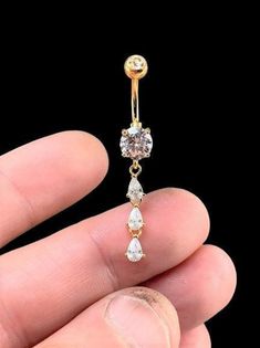 a person is holding an earring in their hand