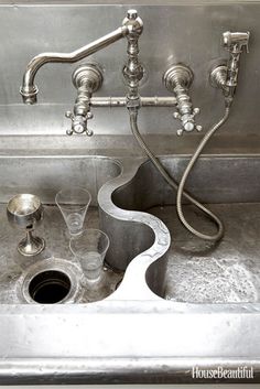 a sink that has some wine glasses in it