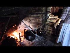 a woman standing next to a fire in a room filled with pots and pans