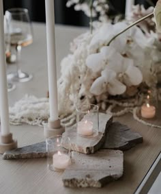 candles and flowers on a table with rocks