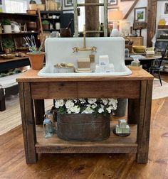 an old fashioned sink is on display in a store with lots of flowers and candles