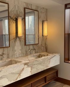 a marble bathroom with double sinks and mirrors