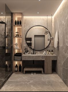 a bathroom with marble walls and flooring has a large round mirror above the sink